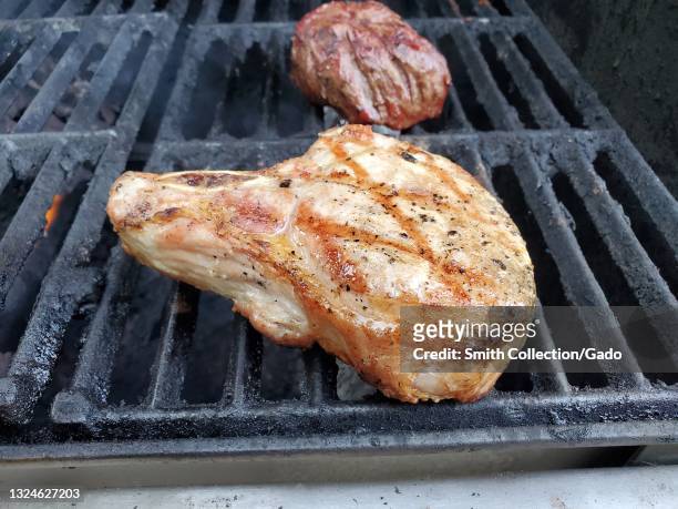 Duroc heirloom pork chop from Roam Butcher's Shop, grilling on a backyard barbecue in preparation for Father's Day, Lafayette, California, June 19,...