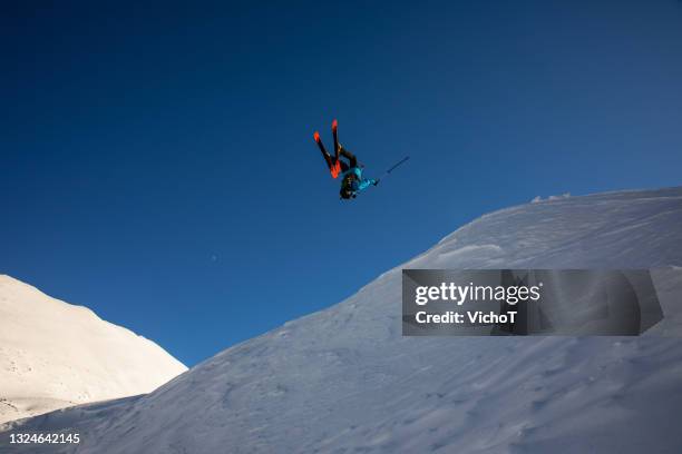 free-skier in the air after making huge backflip jump in the back country mountain - high contrast athlete stock pictures, royalty-free photos & images