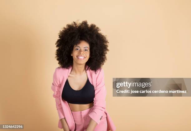 pretty woman afro model, with suit, on plain background - flerfärgad kostym bildbanksfoton och bilder