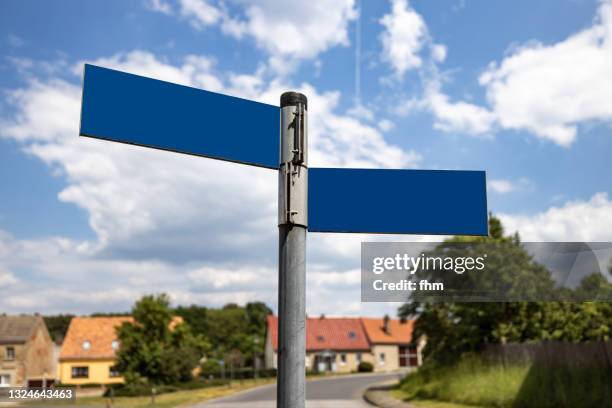 empty street name signs in a tiny village - straatnaambord stockfoto's en -beelden