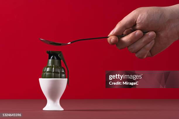 cracking a grenade as an egg in an eggcup - hand grenade bildbanksfoton och bilder