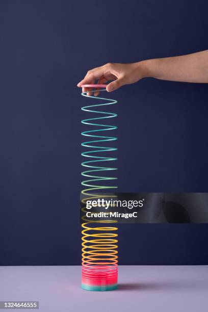 hand stretching colorful coil toy - molla foto e immagini stock