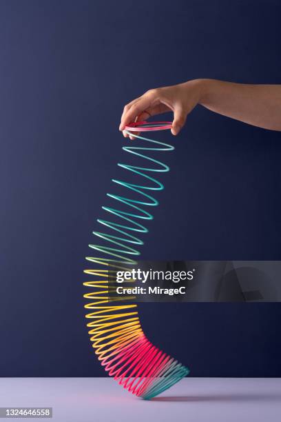 hand playing with colorful coil toy - metal coil toy stock-fotos und bilder