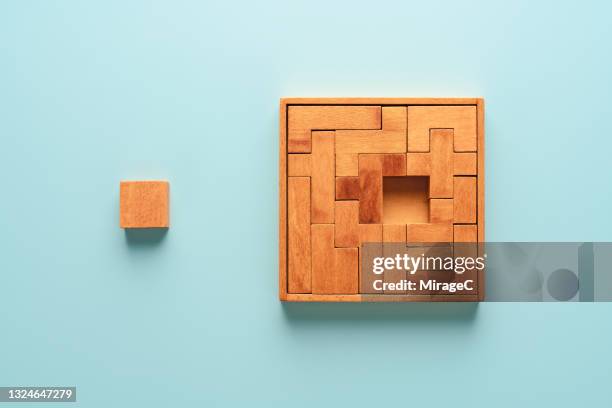 wooden puzzle with a missing piece - posicionamiento fotografías e imágenes de stock