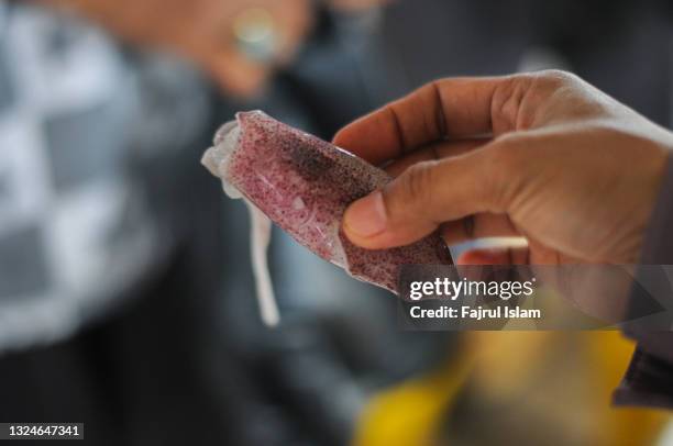 cropped image of hand holding squid in jakarta - thimble stock pictures, royalty-free photos & images