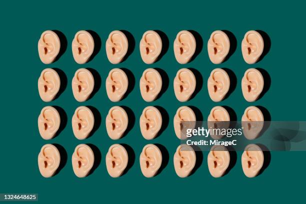 neatly arranged models of human ear on green - human ear foto e immagini stock