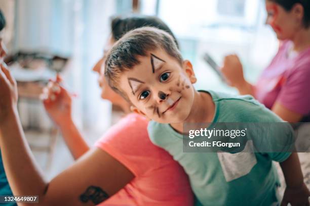 mommy is doing face painting for her son - ansiktsmålning bildbanksfoton och bilder