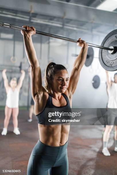 athletic woman exercising with barbell during cross training in a gym. - snatch weightlifting 個照片及圖片檔