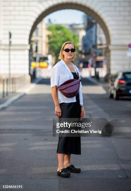 Tina Haase is seen wearing white Uniqlo linen shirt, Max Mara sunglasses, Gina Tricot skirt in black, Scholl clogs, W concept croissant bag in...