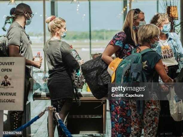 passengers queue in a airport departure lounge. - cleveland ohio coronavirus stock pictures, royalty-free photos & images