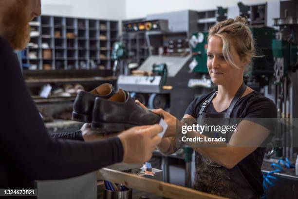 female cobbler and customer in a shoemaker store after reopening in the new normal - cobbler stock pictures, royalty-free photos & images