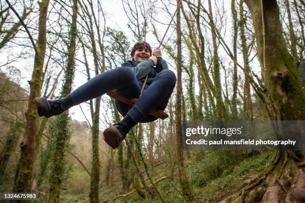 teenage boy on rope swing - altalena di corda foto e immagini stock