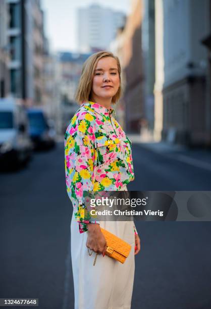Tina Haase is seen wearing white Bermuda shorts &other stories, Essentiel Antwerp blouse with floral print, orange Fendi bag, pink Zara he on June...