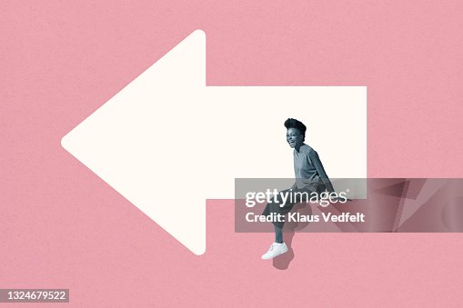 Cheerful young woman sitting on arrow Cheerful young woman sitting on arrow