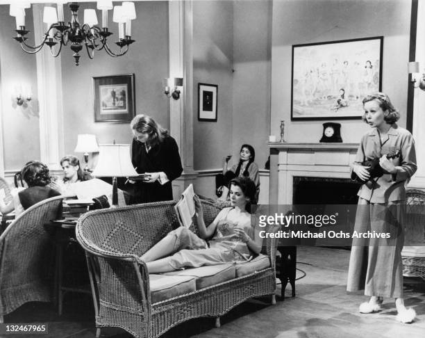 Mary-Robin Redd playing a musical instrument as others relax in scenes from the film 'The Group', 1966.