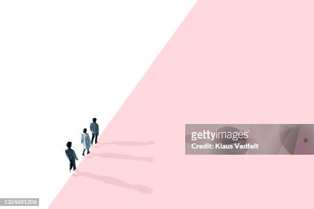 multi-ethnic friends walking at edge of pink wall - three people walking stock pictures, royalty-free photos & images