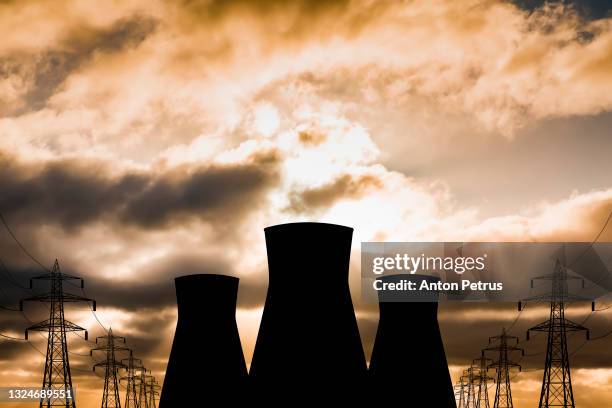 nuclear power plant on the background of sunset - radioactiviteit stockfoto's en -beelden