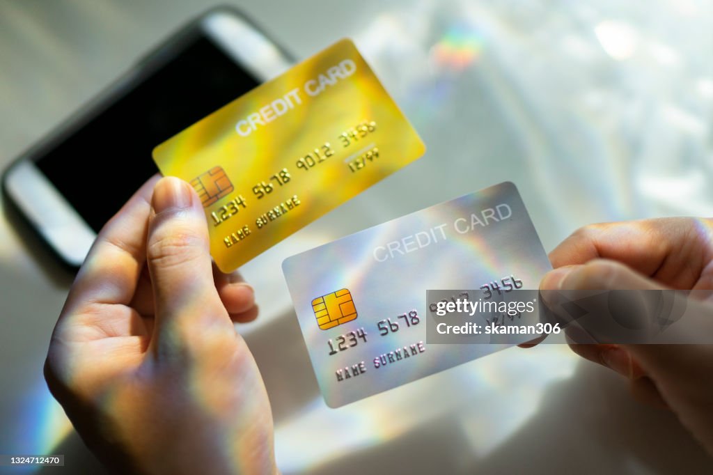 Close up Hand holding Blank credit card black,gold,platinum color with spectrum light and shadow background