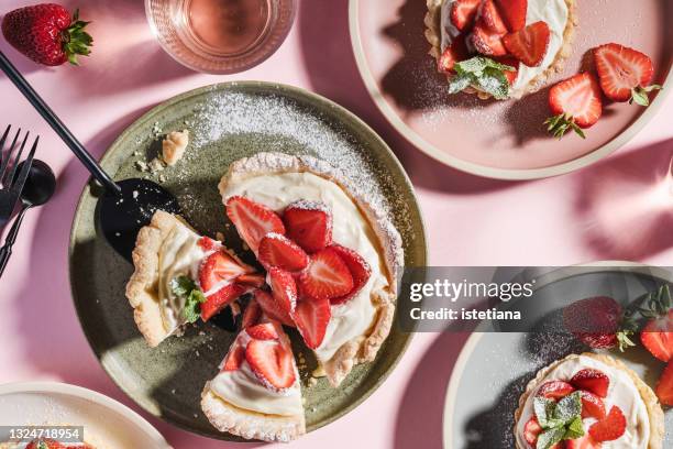 summer sweet strawberry tarts on pink background with harsh shadows - tarta postre fotografías e imágenes de stock