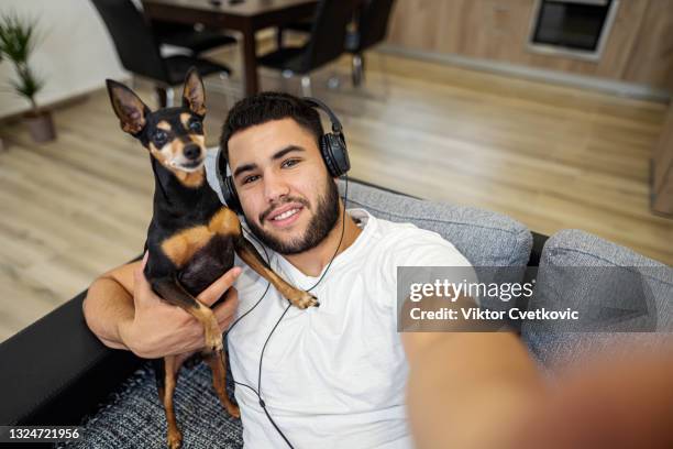 young man taking selfie with his dog pet - pincher bildbanksfoton och bilder
