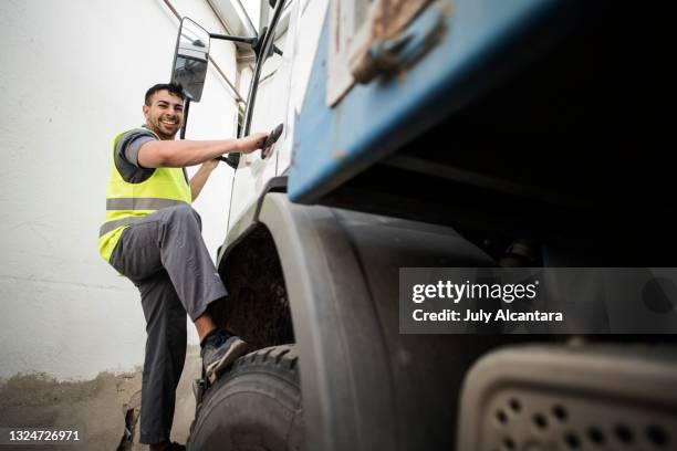 construction worker getting on truck happy looking at camera - earth mover truck stock pictures, royalty-free photos & images