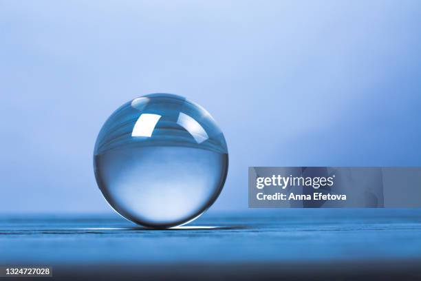crystal ball on ultimate gray background. concept of magic esoteric rituals. trendy colors of the year 2021. front view and close-up - glazen bol stockfoto's en -beelden