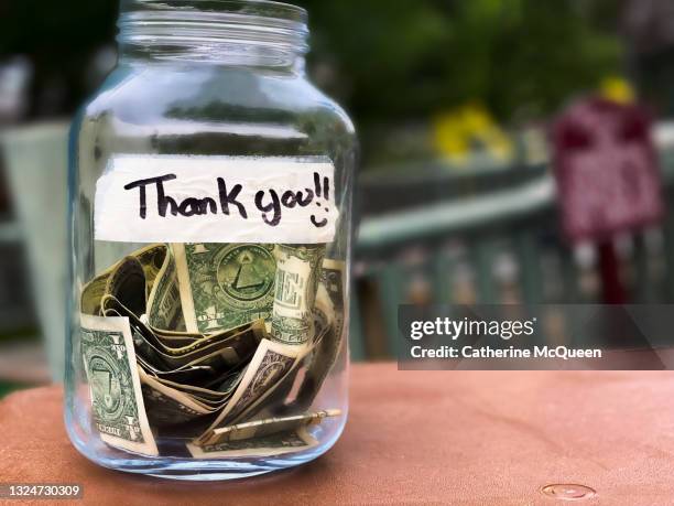 glass tip jar at checkout counter - minimum wage stockfoto's en -beelden