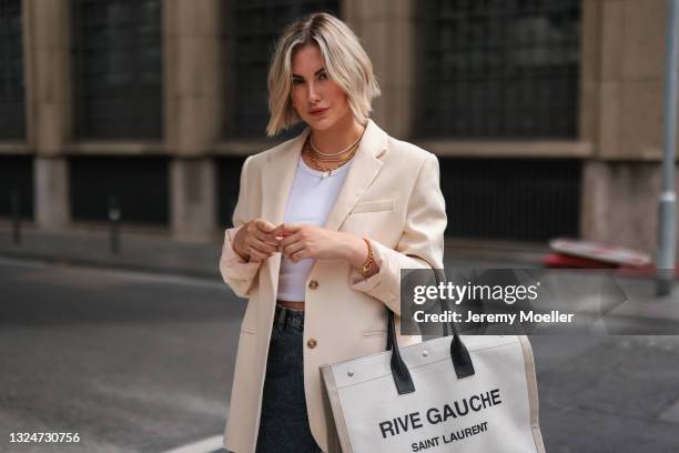 Franzi Koenig wearing white Weekday top, beige Zara blazer, grey jeans, Saint Laurent leather bag and Fafe Collection jewelry on June 18, 2021 in...