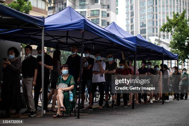 Residents wear a mask while lining up to receive the COVID-19 vaccines at a vaccination site on June 21, 2021 in Wuhan, China. As of last month, the...