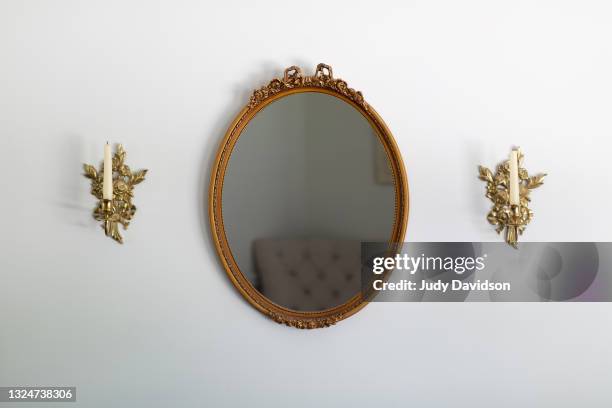 ornate oval wall mirror with side brass candle scones - mirror object - fotografias e filmes do acervo