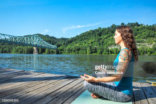 woman doing yoga by river - ohio river stock pictures, royalty-free photos & images