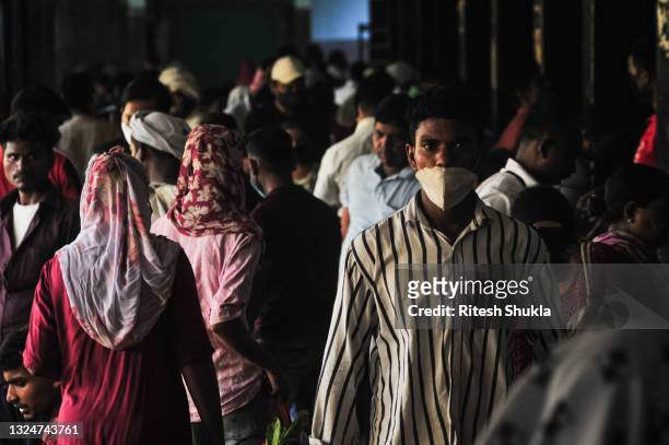 People walk among the stalls at a wholesale vegetable market as Uttar Pradesh, India's most populous state, re-opens on June 21, 2021 in Varanasi,...