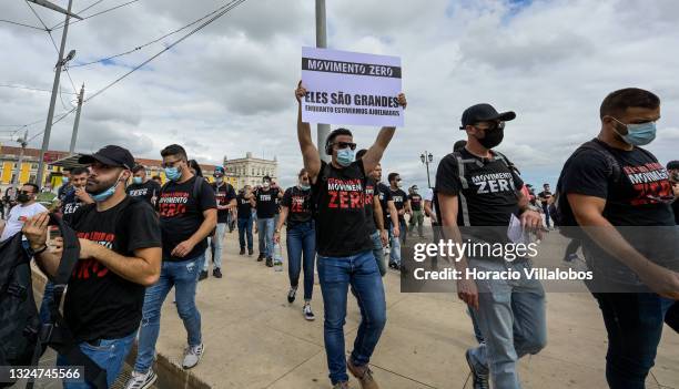 Members of Portuguese security forces wear protective masks and Movimento Zero t-shirts as they march demanding better working conditions in Praça do...