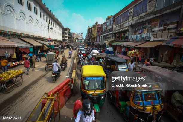 Traffic and pedestrians mingle on a street as Uttar Pradesh, India's most populous state, re-opens on June 21, 2021 in Varanasi, India. India has...