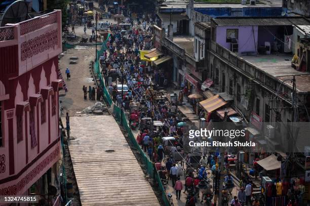 Traffic and pedestrians mingle on a street as Uttar Pradesh, India's most populous state, re-opens on June 21, 2021 in Varanasi, India. India has...