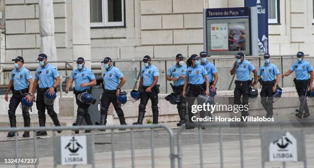 Mask-clad police officers cordon off a perimeter outside the Ministry of Internal Administration as members of Portuguese security forces march...