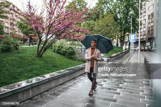 happy businessman walking down the street - people rain happy stockfoto's en -beelden