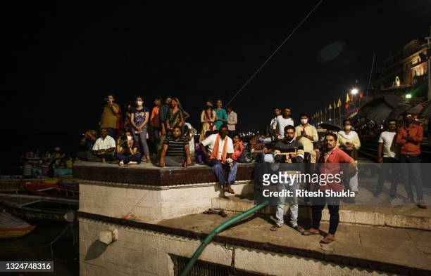 Hindu devotees gather to attend evening prayers as Uttar Pradesh, India's most populous state, re-opens on June 21, 2021 at the Dashashwmedh Ghat,...