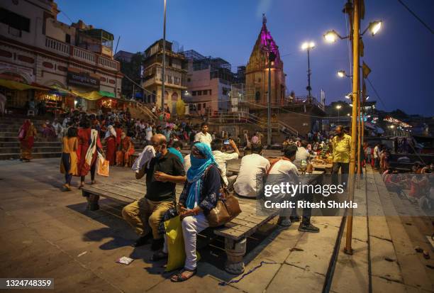 Hindu devotees gather to attend evening prayers as Uttar Pradesh, India's most populous state, re-opens on June 21, 2021 at the Dashashwmedh Ghat,...