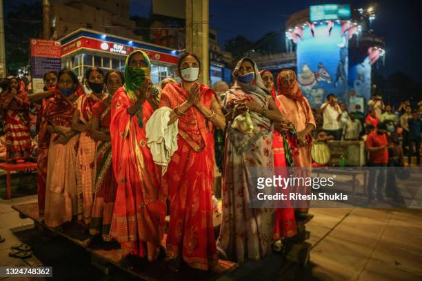 Hindu women gather to attend evening prayers as Uttar Pradesh, India's most populous state, re-opens on June 21, 2021 at the Dashashwmedh Ghat, along...