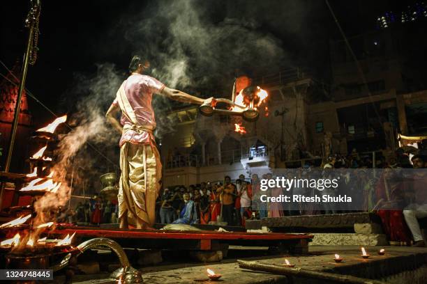 Hindu priest performs evening prayers as Uttar Pradesh, India's most populous state, re-opens on June 21, 2021 at the Dashashwmedh Ghat, along the...