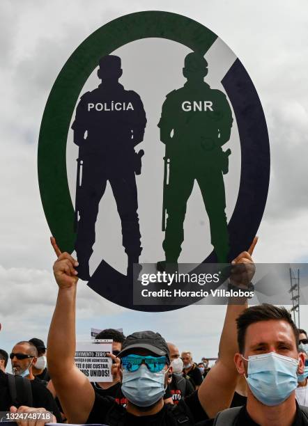 Members of Portuguese security forces wear protective masks and hoist Movimento Zero signs as they march demanding better working conditions in Praça...