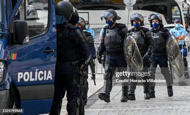 Mask-clad police officers in full anti-riot gear cordon off a perimeter outside the Ministry of Internal Administration as members of Portuguese...