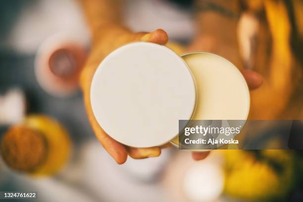 close up of unrecognizable woman holding an open face sunscreen. - shea butter stock pictures, royalty-free photos & images
