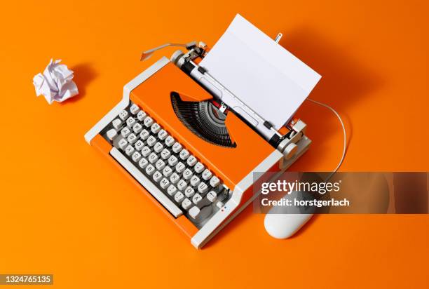 máquina de escribir naranja de los años 70 con página en blanco - typewriter fotografías e imágenes de stock