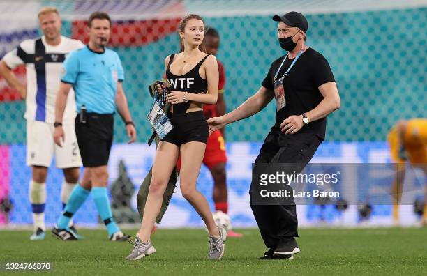 Pitch invader is removed from the pitch by ground staff during the UEFA Euro 2020 Championship Group B match between Finland and Belgium at Saint...
