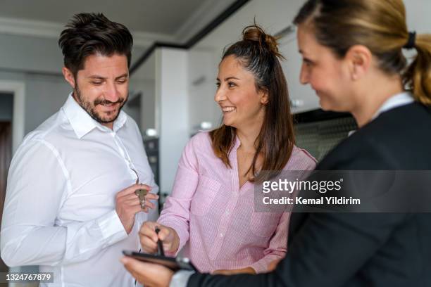new home owners receiving the keys to a new apartment - signing tablet stock pictures, royalty-free photos & images