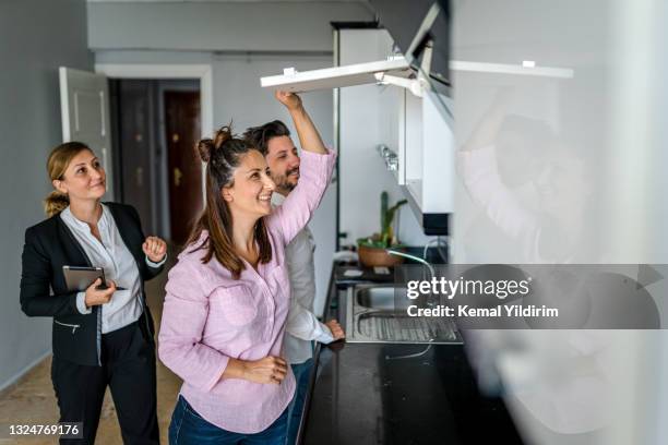 agente de bienes raíces mostrando una propiedad a una familia feliz - real estate sign fotografías e imágenes de stock