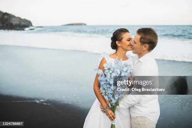 wedding couple enjoying on beach in bali. young and happy. tropical destination wedding - ranunculus wedding bouquet stock pictures, royalty-free photos & images