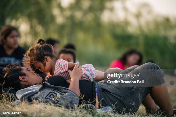 Migrant families wait to be accounted for and taken to a border patrol processing facility after crossing the Rio Grande into the U.S. On June 21,...